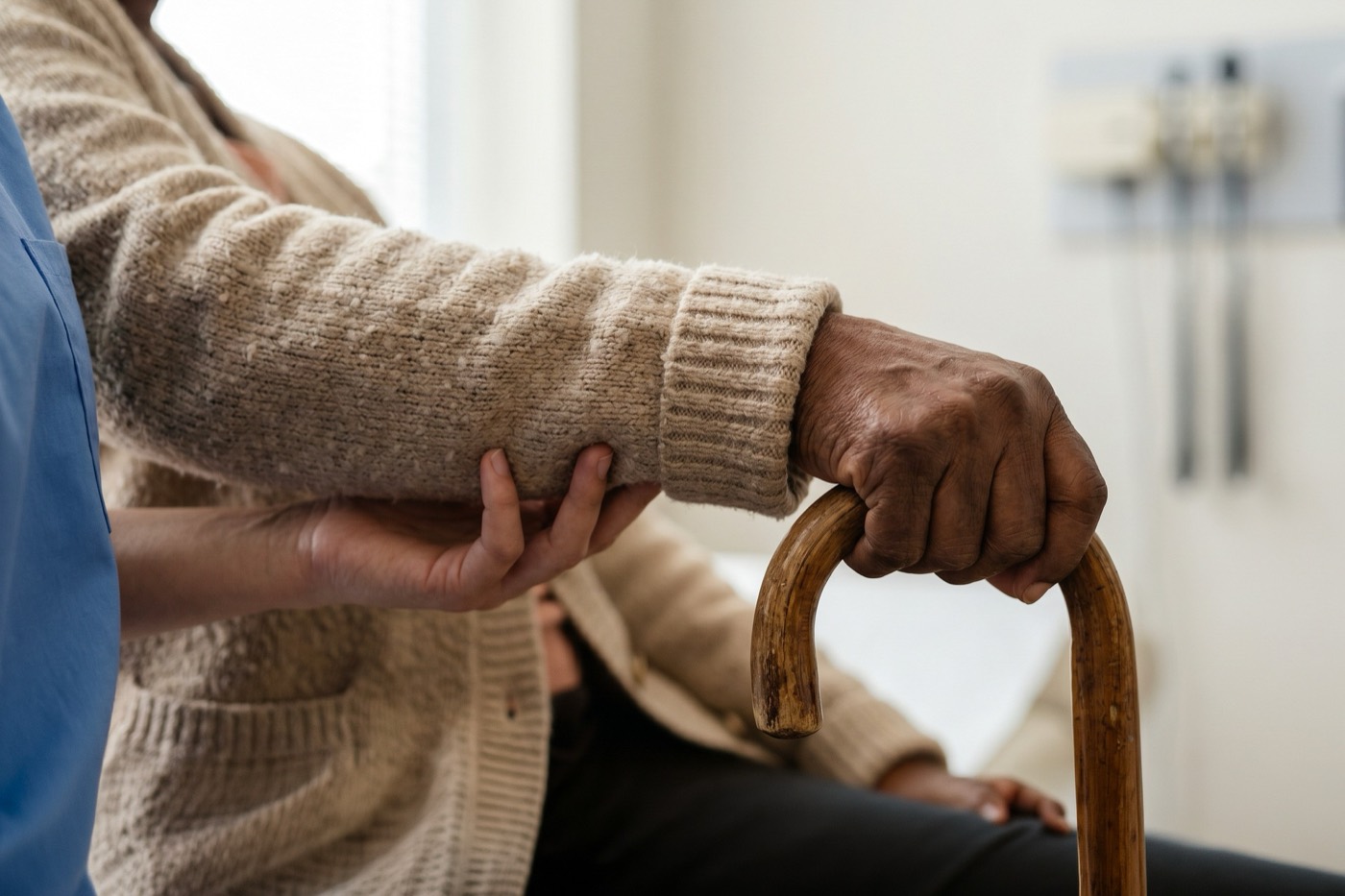 An AZA Services caregiver steadying a client's arm as they stand with a walking cane
